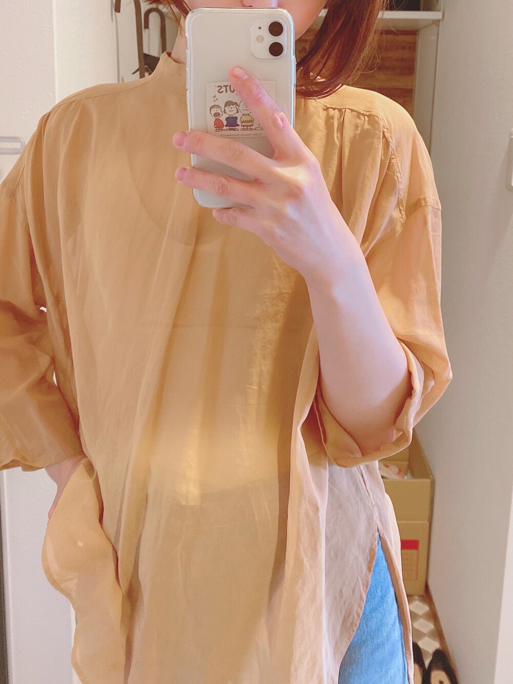 ブルー系のデニムパンツ、ベージュ系のサンダル、オレンジ系のシャツ/ブラウスを着用したレディースの冬コーディネートの2枚目の写真