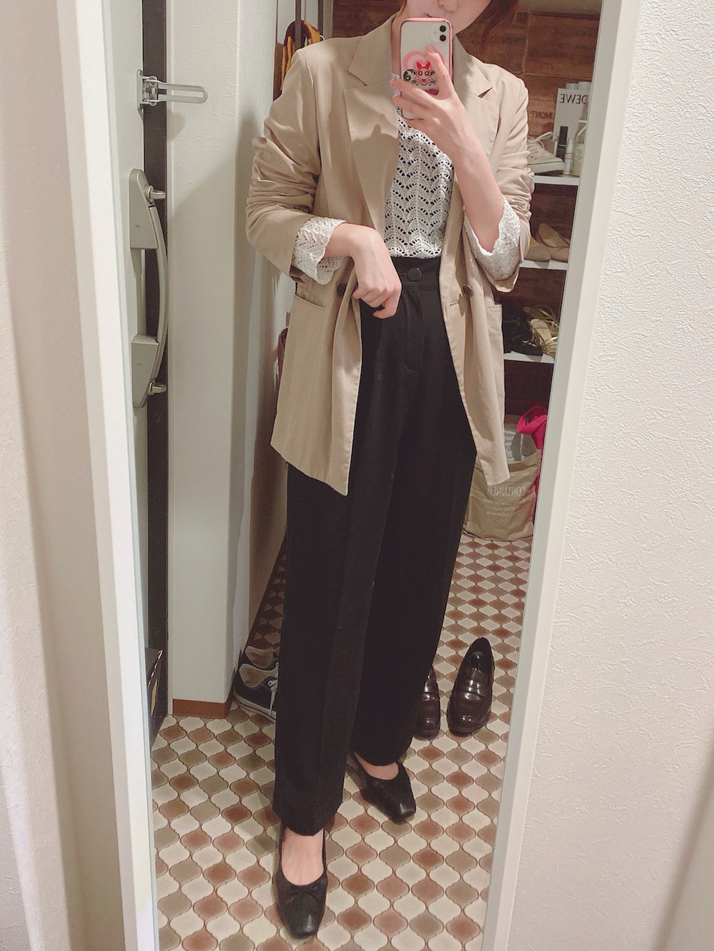 ベージュ系のテーラードジャケット、ブラック系のスラックス、ブラック系のバレエシューズを着用したレディースの春コーディネートの2枚目の写真