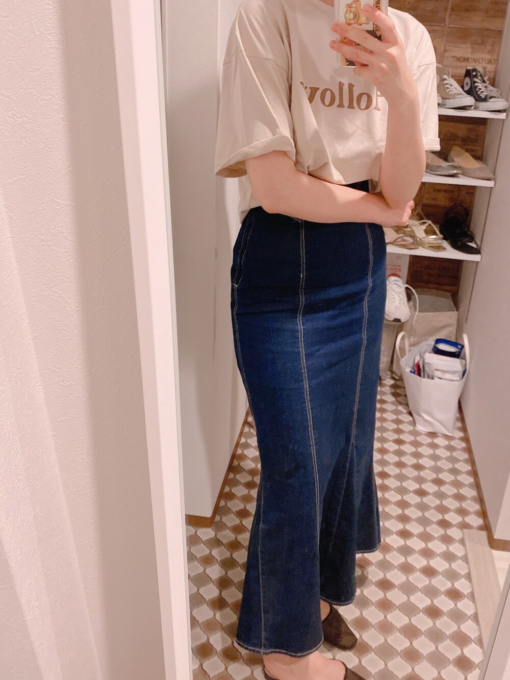 ベージュ系のTシャツ/カットソー、ブルー系のデニムスカート、ブラック系のパンプスを着用したレディースの夏コーディネートの3枚目の写真