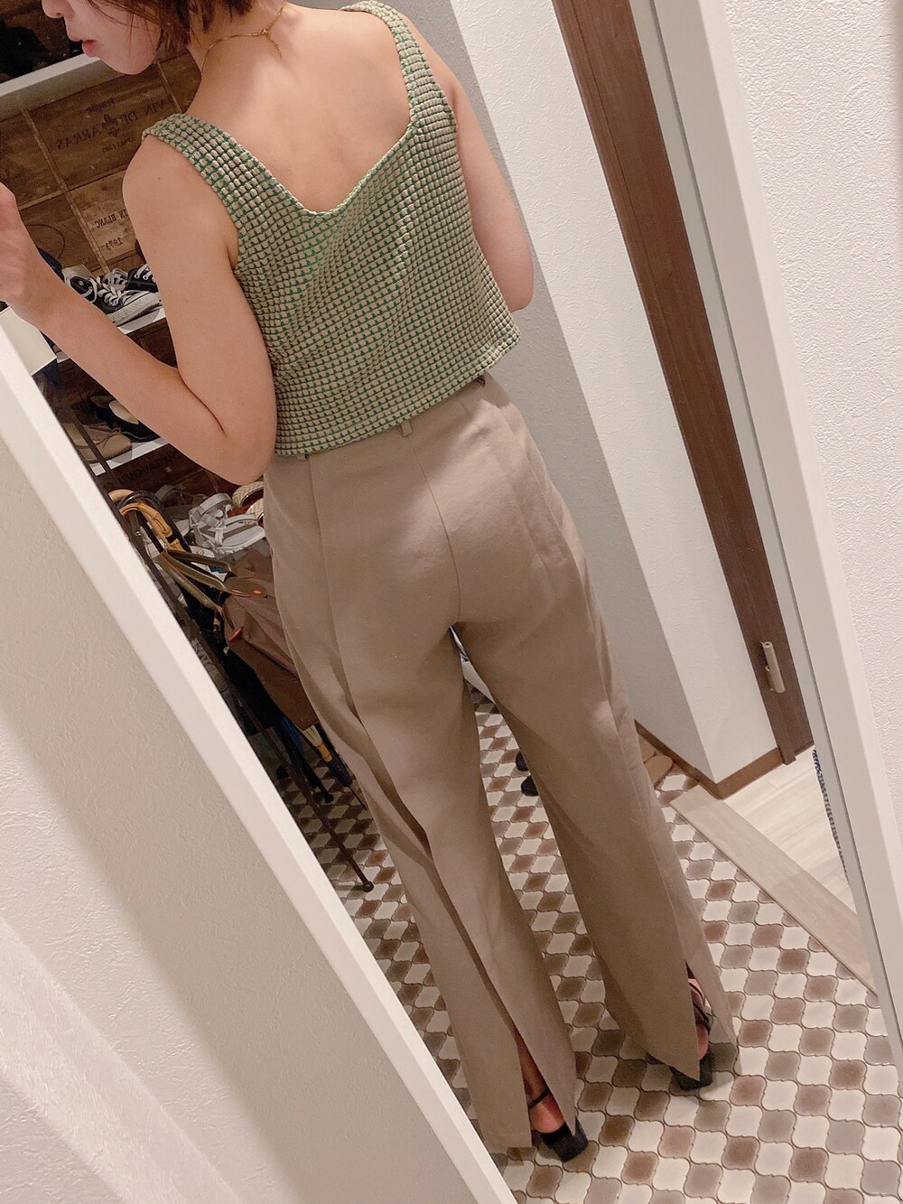 ベージュ系のパンツ、ベージュ系のタンクトップ、ブラック系のサンダルを着用したレディースの夏コーディネートの3枚目の写真