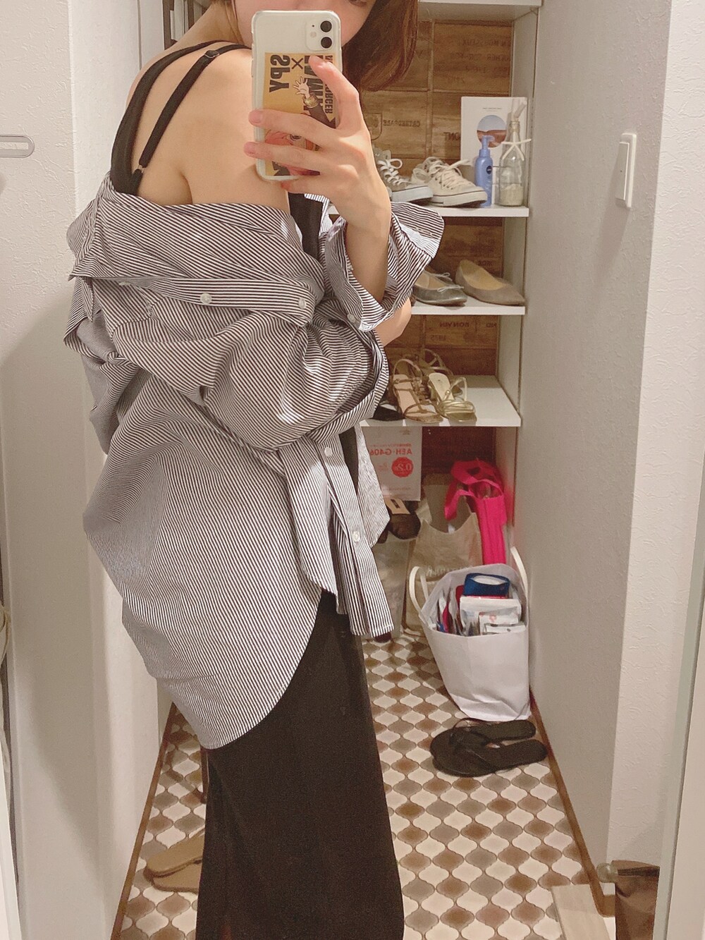 ブラック系のワンピース、ブラック系のサンダル、ブルー系のシャツ/ブラウスを着用したレディースの夏コーディネートの2枚目の写真