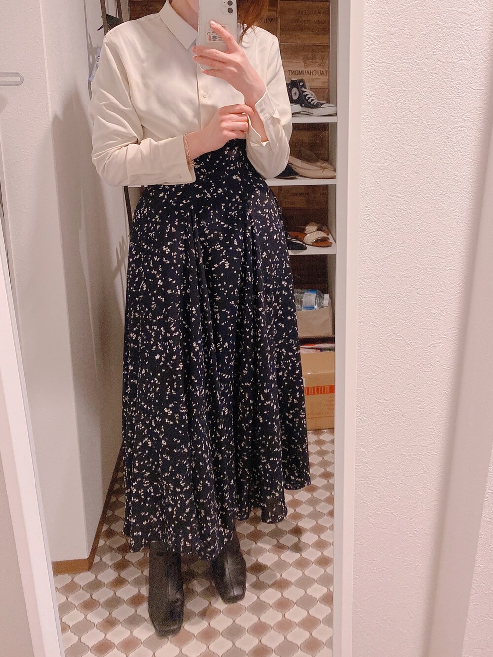 ブラック系のスカート、ブラック系のブーツ、ベージュ系のシャツ/ブラウスを着用したレディースの春コーディネートの2枚目の写真