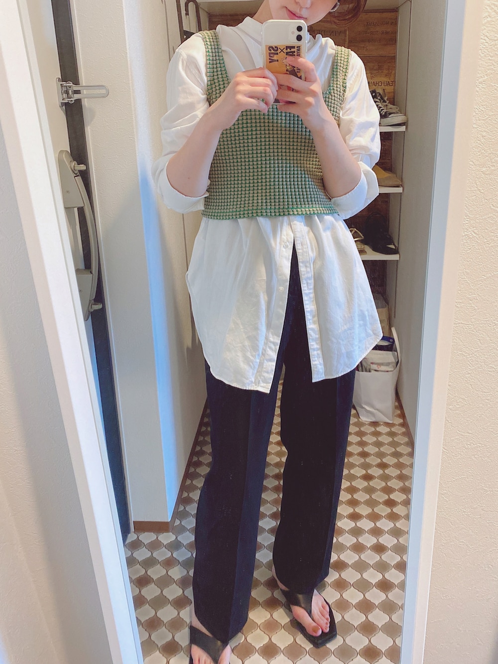 ブラック系のスラックス、ブラック系のサンダル、ベージュ系のタンクトップを着用したレディースの夏コーディネートの3枚目の写真