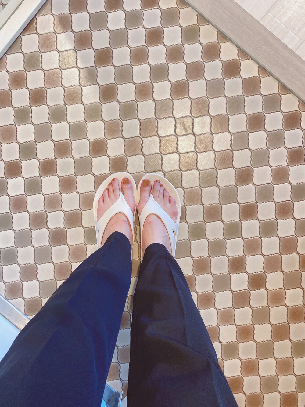 ブラック系のスラックス、ブラック系のサンダル、ベージュ系のタンクトップを着用したレディースの夏コーディネートの5枚目の写真