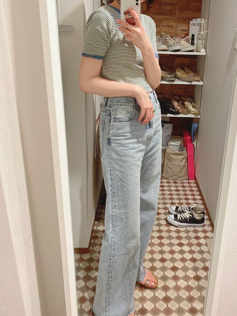 ブルー系のデニムパンツ、イエロー系のサンダル、グリーン系のTシャツ/カットソーを着用したレディースの春コーディネートの3枚目の写真