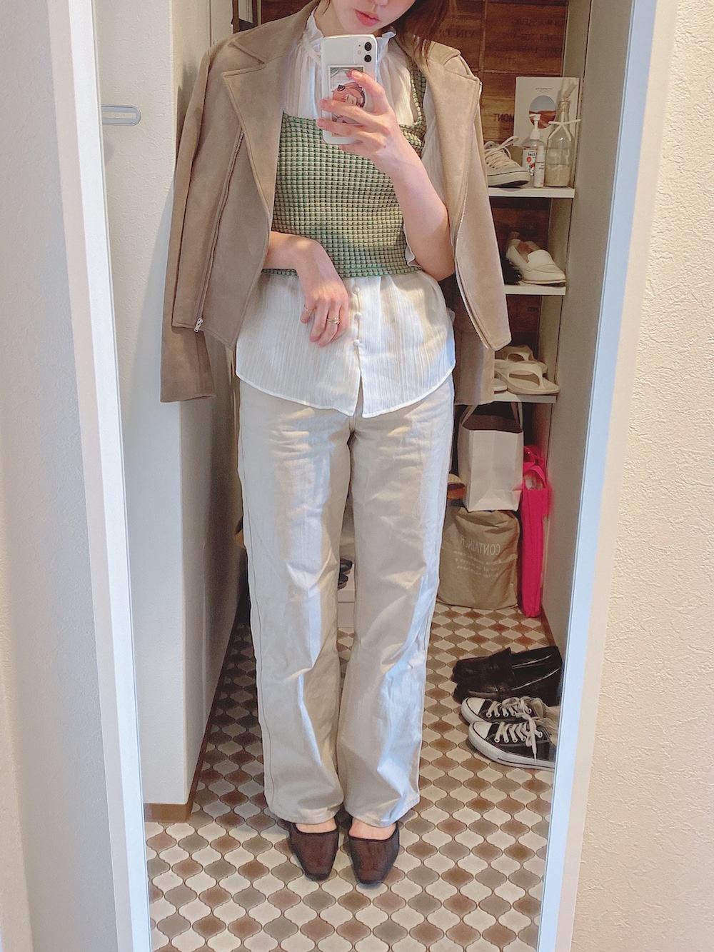 ベージュ系のデニムパンツ、ブラック系のパンプス、ベージュ系のタンクトップを着用したレディースの春コーディネートの2枚目の写真