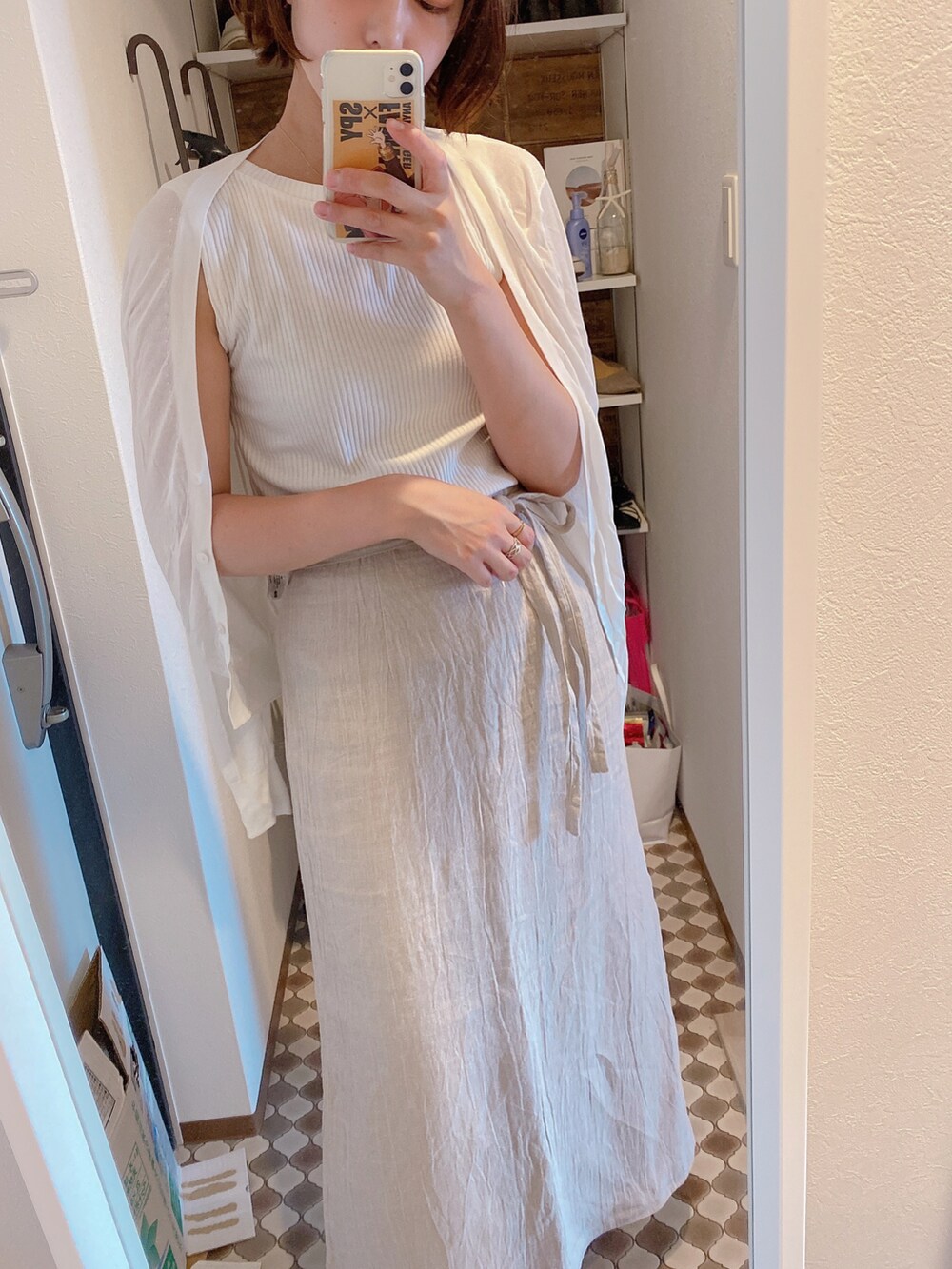 ベージュ系のスカート、ホワイト系のトップス、ホワイト系のカーディガン/ボレロを着用したレディースの夏コーディネートの2枚目の写真
