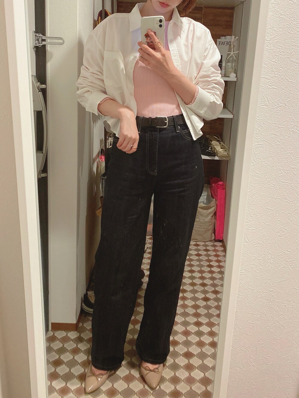 ピンク系のニット/セーター、ブルー系のデニムパンツ、ベージュ系のバレエシューズを着用したレディースの春コーディネートの2枚目の写真