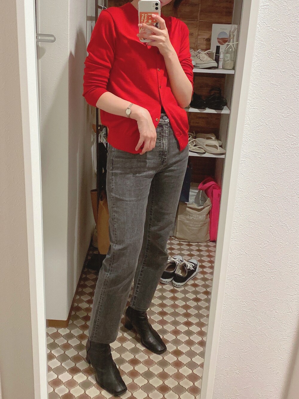 レッド系のカーディガン/ボレロ、ブラウン系のテーラードジャケット、グレー系のデニムパンツを着用したレディースの秋コーディネートの3枚目の写真