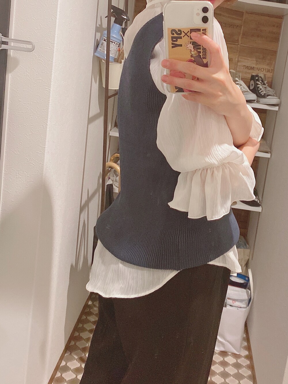 ブルー系のニット/セーター、ブラック系のスラックス、ブラック系のパンプスを着用したレディースの夏コーディネートの2枚目の写真
