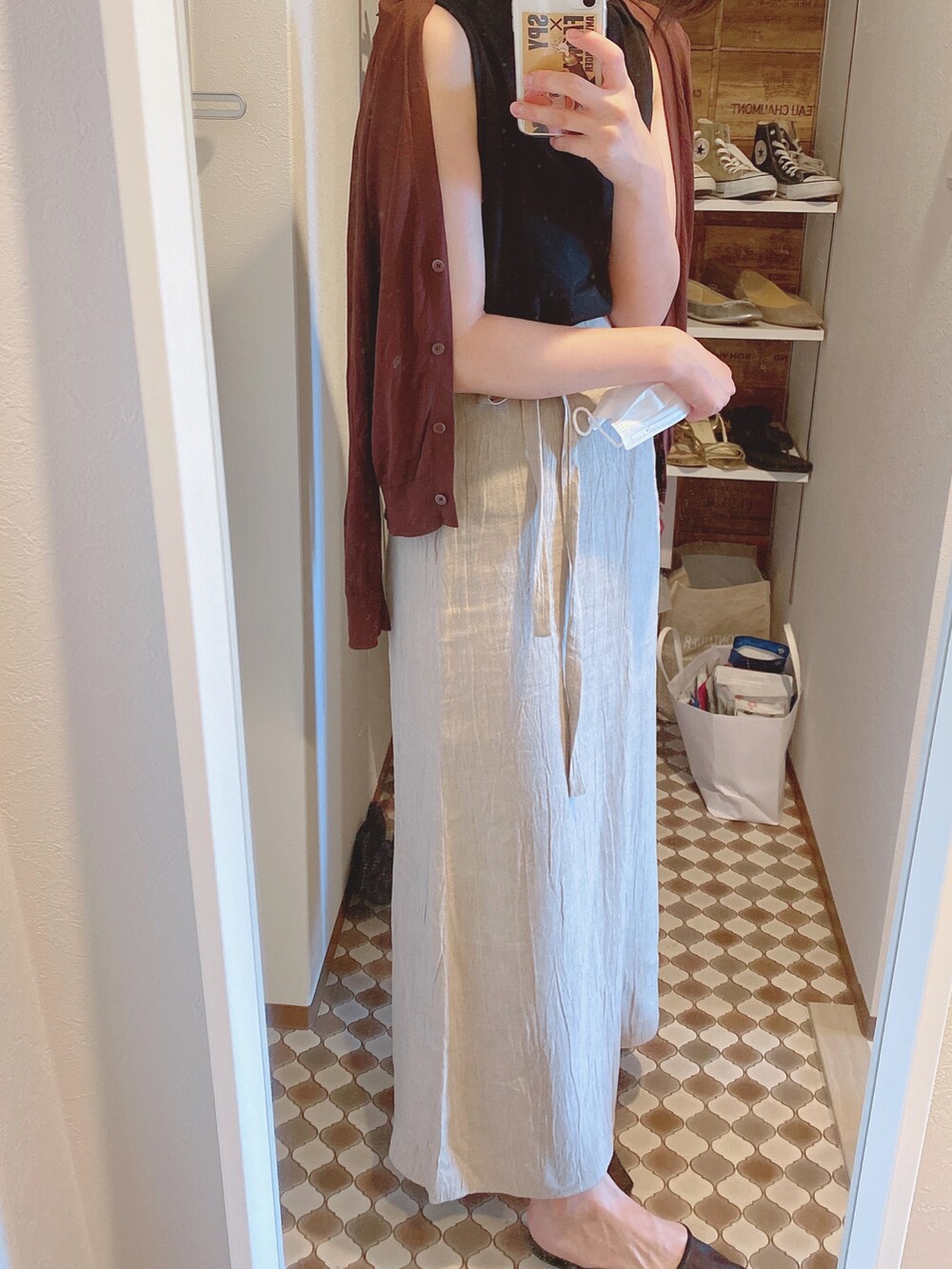 ブラック系のパンプス、ベージュ系のスカート、ブラック系のトップスを着用したレディースの夏コーディネートの2枚目の写真