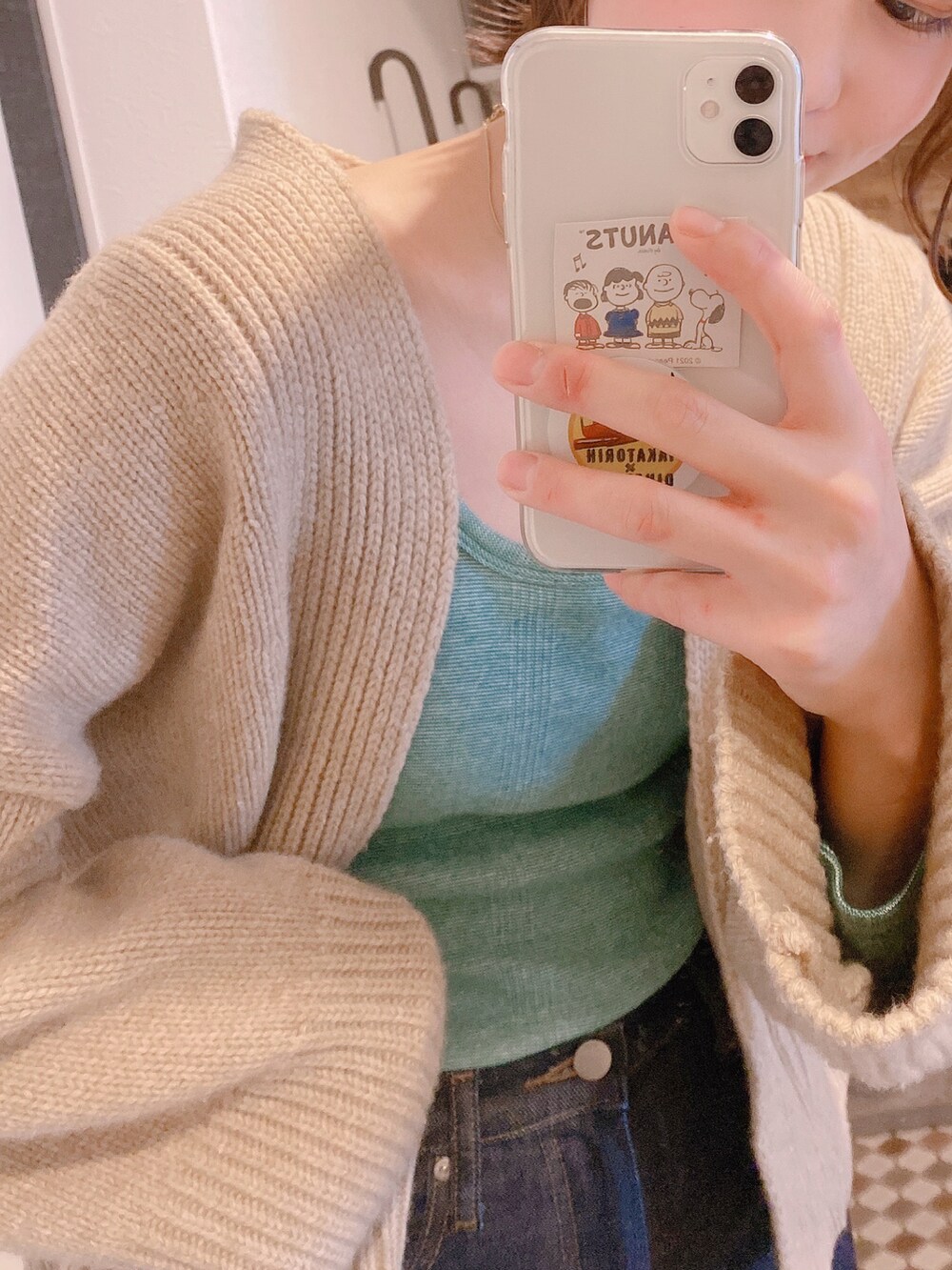 ブルー系のデニムパンツ、グリーン系のTシャツ/カットソー、ベージュ系のカーディガン/ボレロを着用したレディースの春コーディネートの2枚目の写真