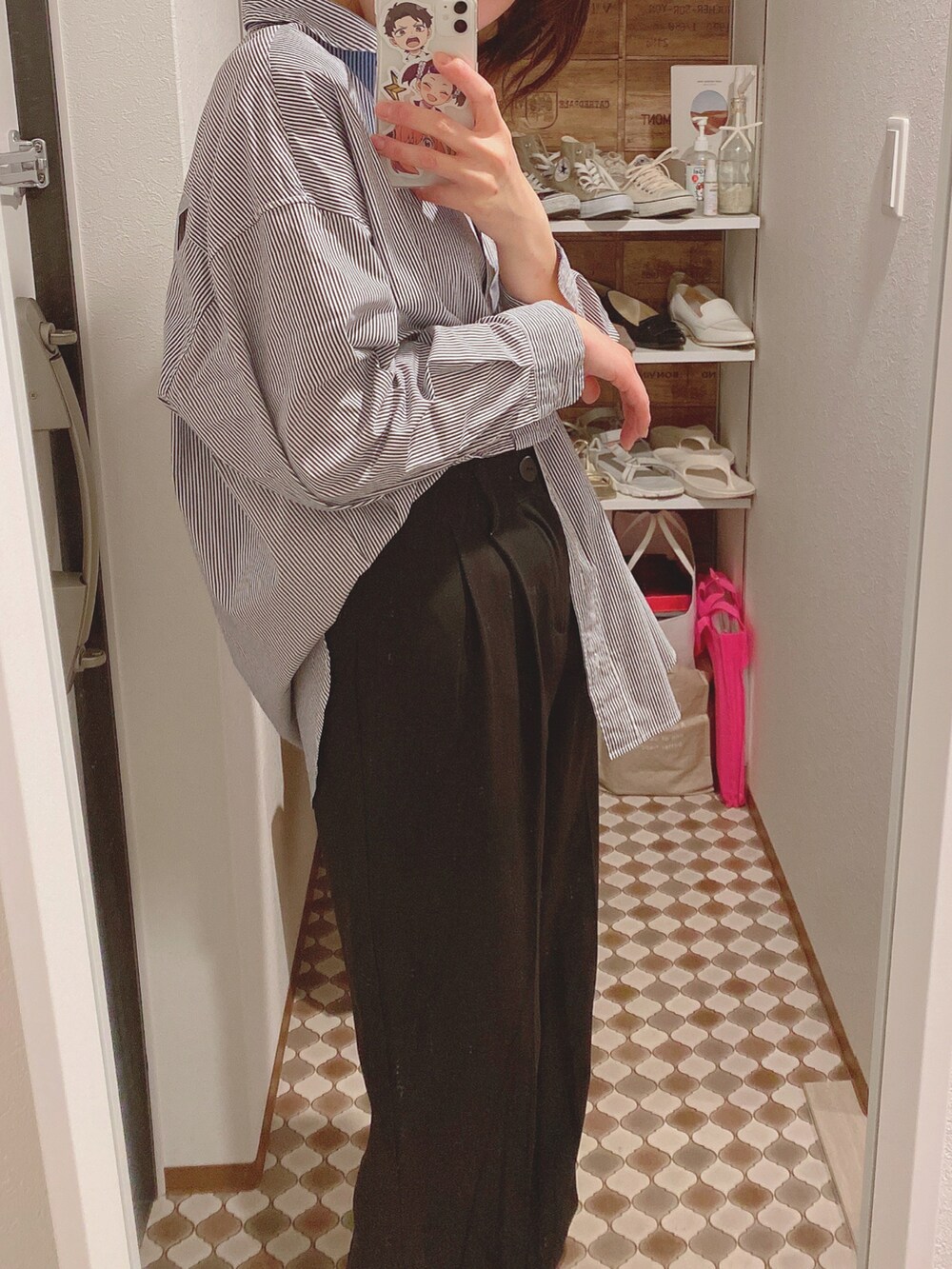 ブラック系のスラックス、ブラック系のパンプス、ブルー系のシャツ/ブラウスを着用したレディースの春コーディネートの3枚目の写真