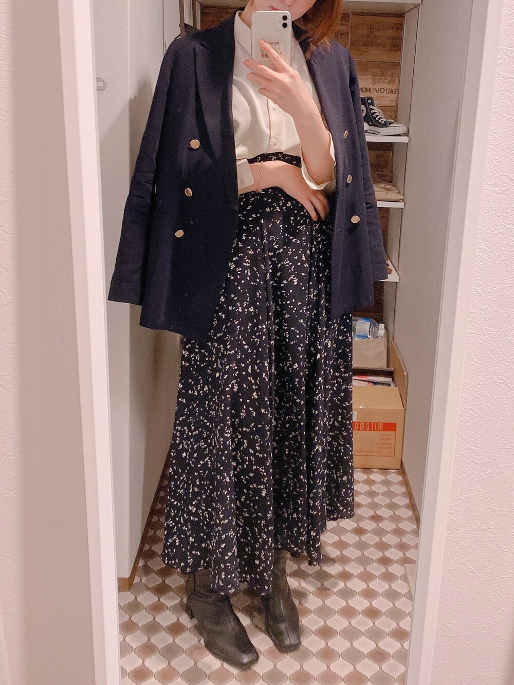 ブラック系のスカート、ブラック系のブーツ、ベージュ系のシャツ/ブラウスを着用したレディースの春コーディネートの3枚目の写真