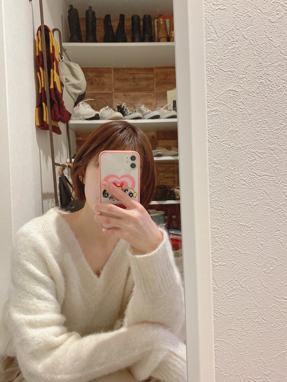 ベージュ系のパンツ、ホワイト系のニット/セーターを着用したレディースの冬コーディネートの2枚目の写真