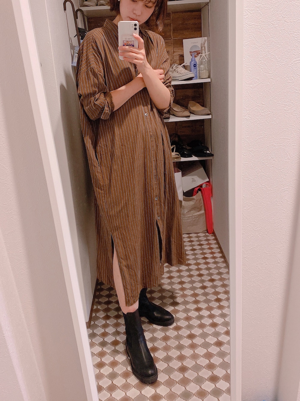 ブラウン系のシャツワンピース、ブラック系のブーツを着用したレディースの秋コーディネートの2枚目の写真