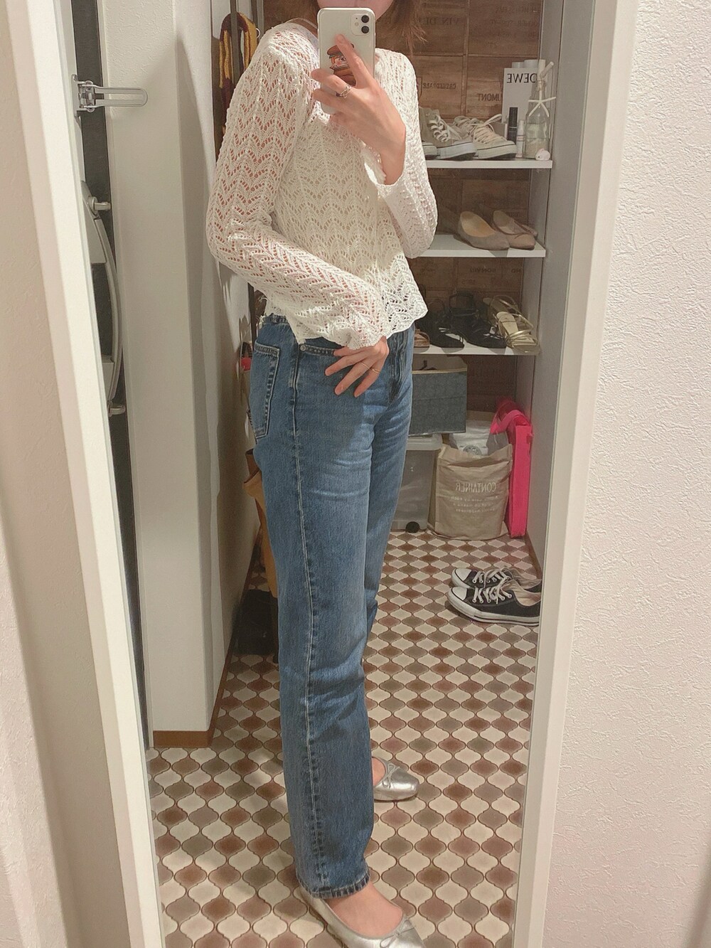 ホワイト系のニット/セーター、ブルー系のデニムパンツを着用したレディースの春コーディネートの2枚目の写真