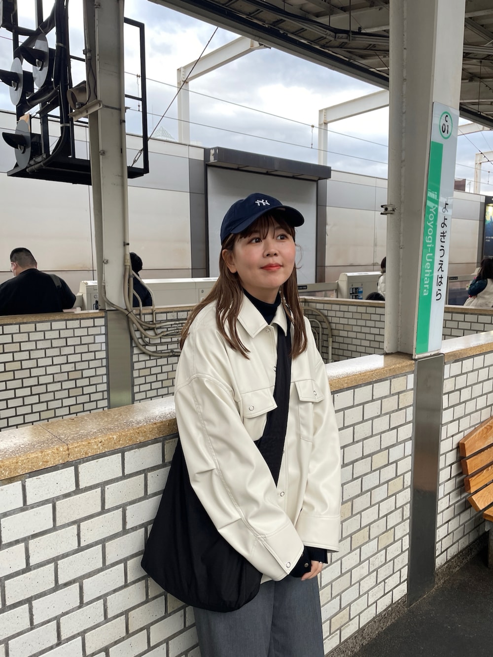 グレー系のスニーカー、ブラック系のショルダーバッグ、ブラック系のニット/セーターを着用したレディースの冬コーディネートの5枚目の写真