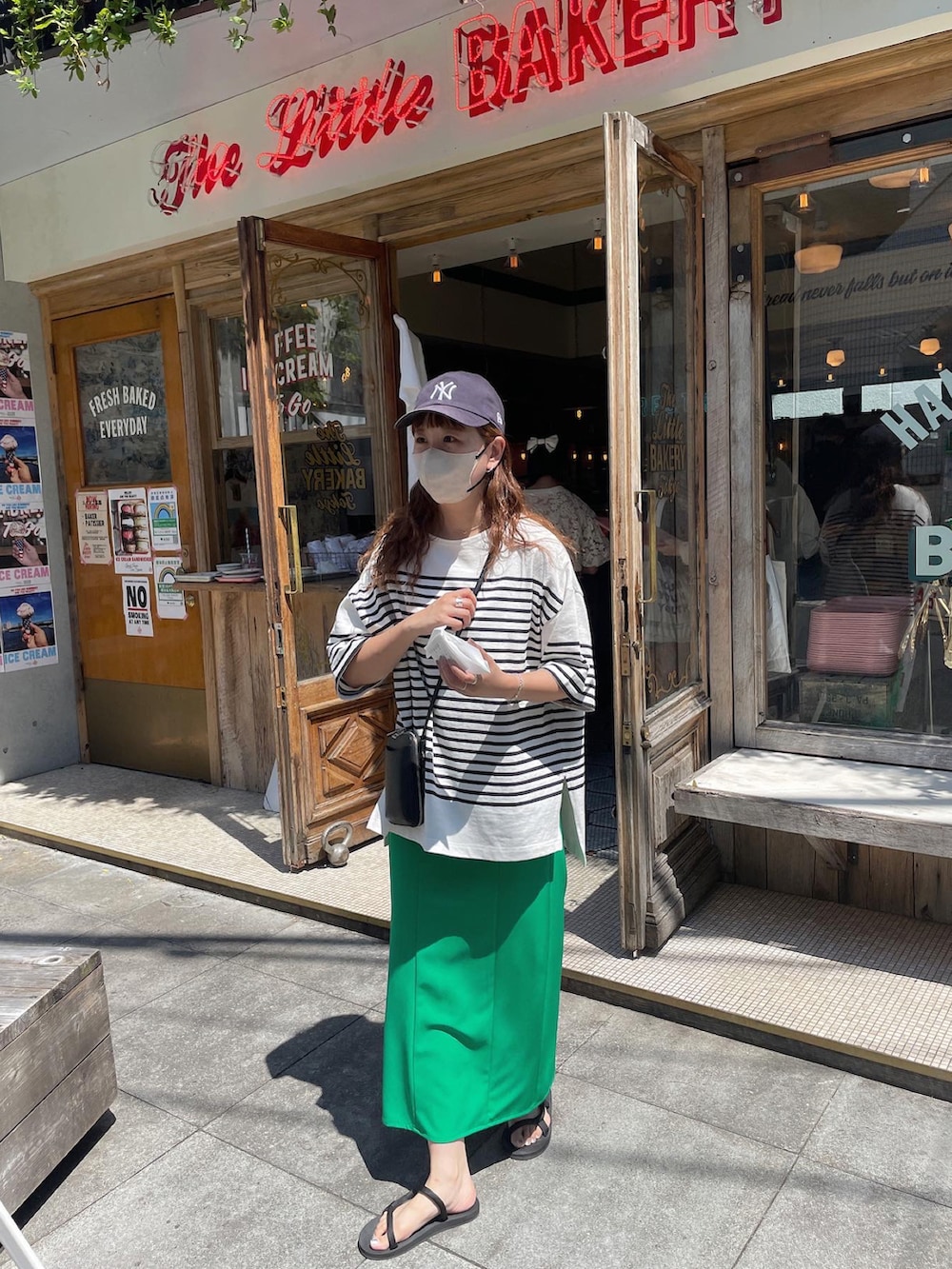 グリーン系のスカート、ブラック系のTシャツ/カットソー、ブラック系のショルダーバッグを着用したレディースの夏コーディネートの4枚目の写真