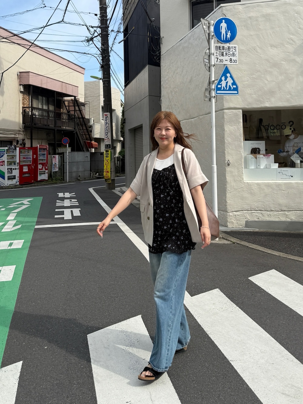 ブルー系のデニムパンツ、ホワイト系のタンクトップ、ブラック系のチュニックを着用したレディースの春コーディネートの6枚目の写真