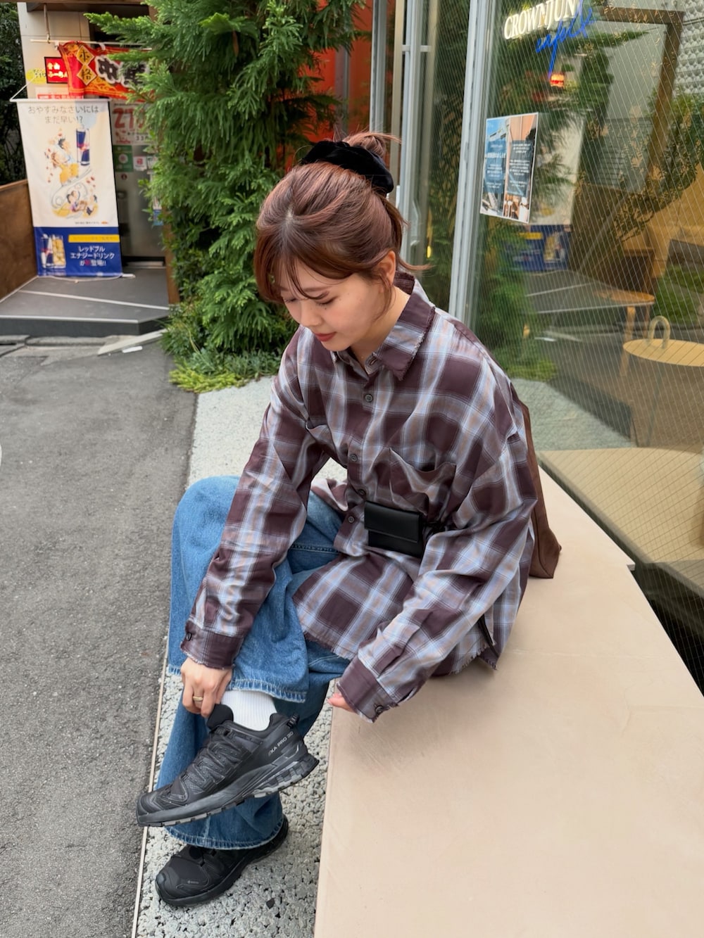 ブラウン系のシャツ/ブラウス、ブルー系のデニムパンツ、ブラック系のボディバッグ/ウエストポーチを着用したレディースの秋コーディネートの2枚目の写真