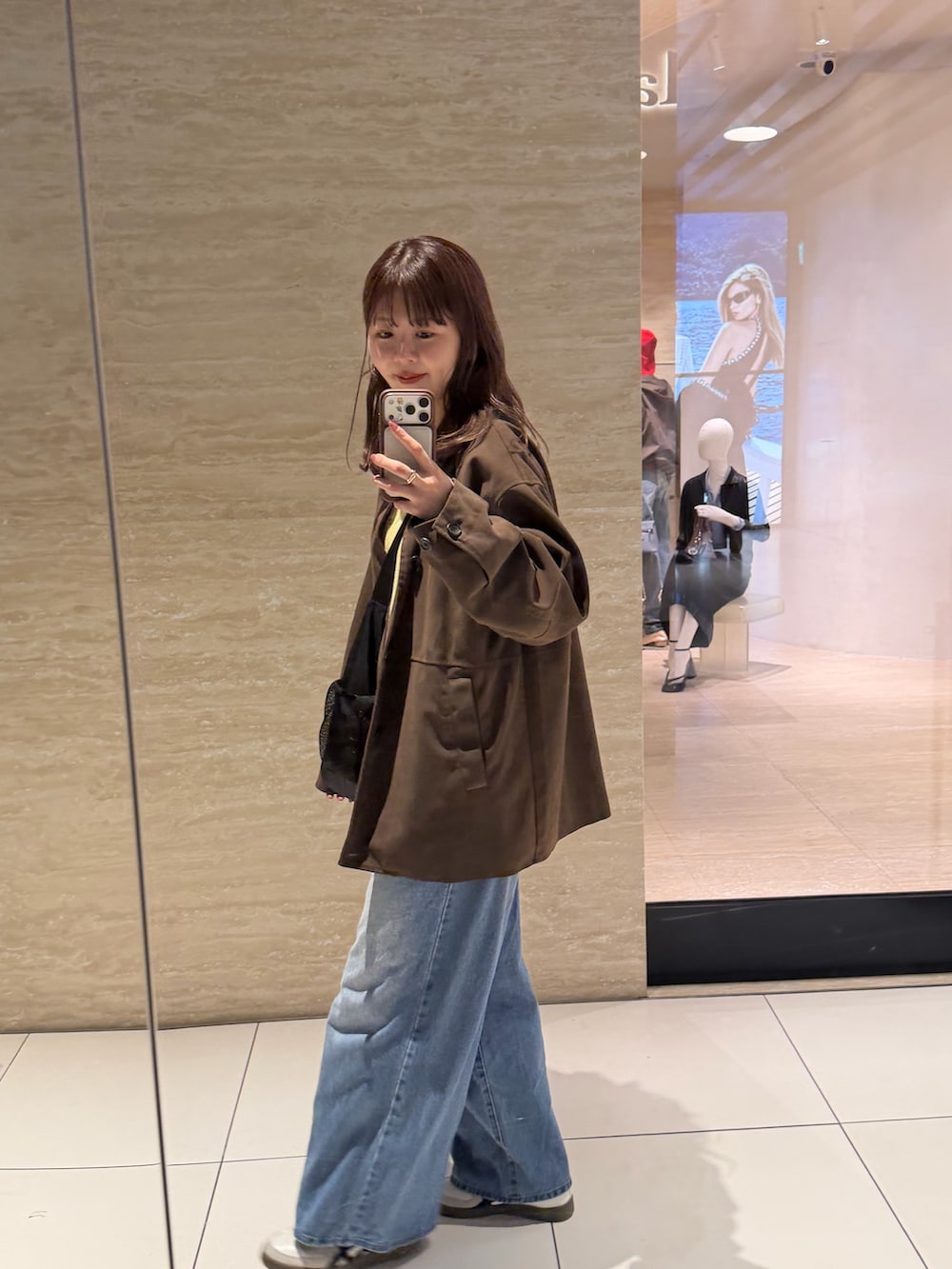 ブラウン系のその他アウター、ブルー系のデニムパンツを着用したレディースの春コーディネートの5枚目の写真