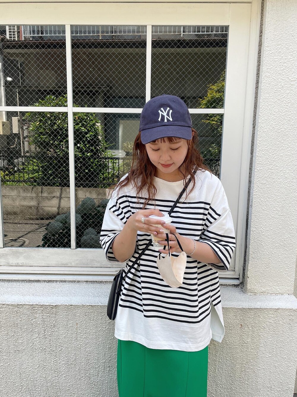 グリーン系のスカート、ブラック系のTシャツ/カットソー、ブラック系のショルダーバッグを着用したレディースの夏コーディネートの5枚目の写真