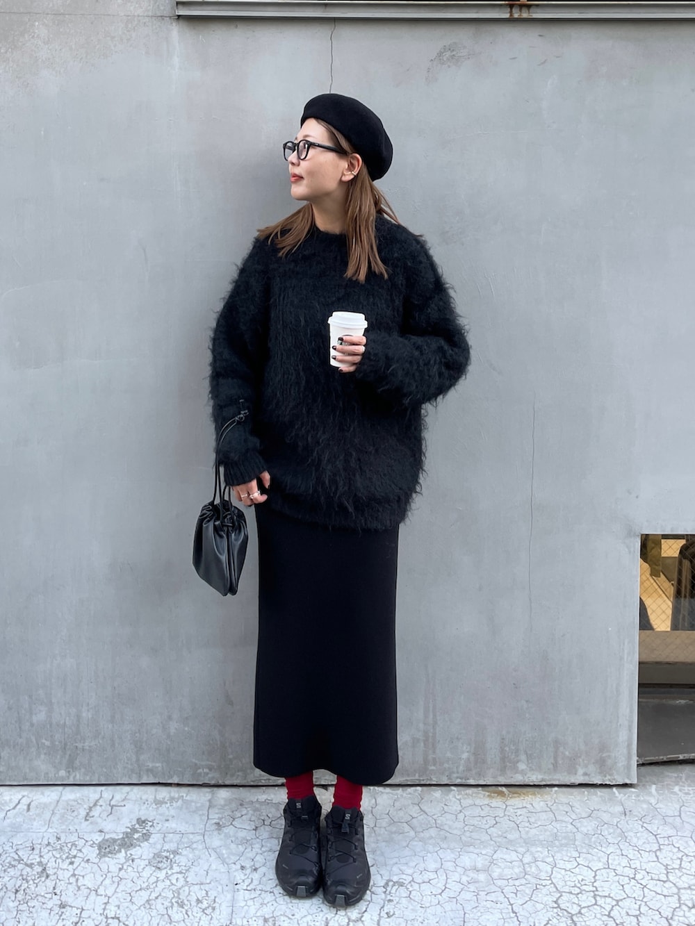 ブラック系のスニーカー、ブラック系のスカート、ブラック系のニット/セーターを着用したレディースの秋コーディネートの5枚目の写真