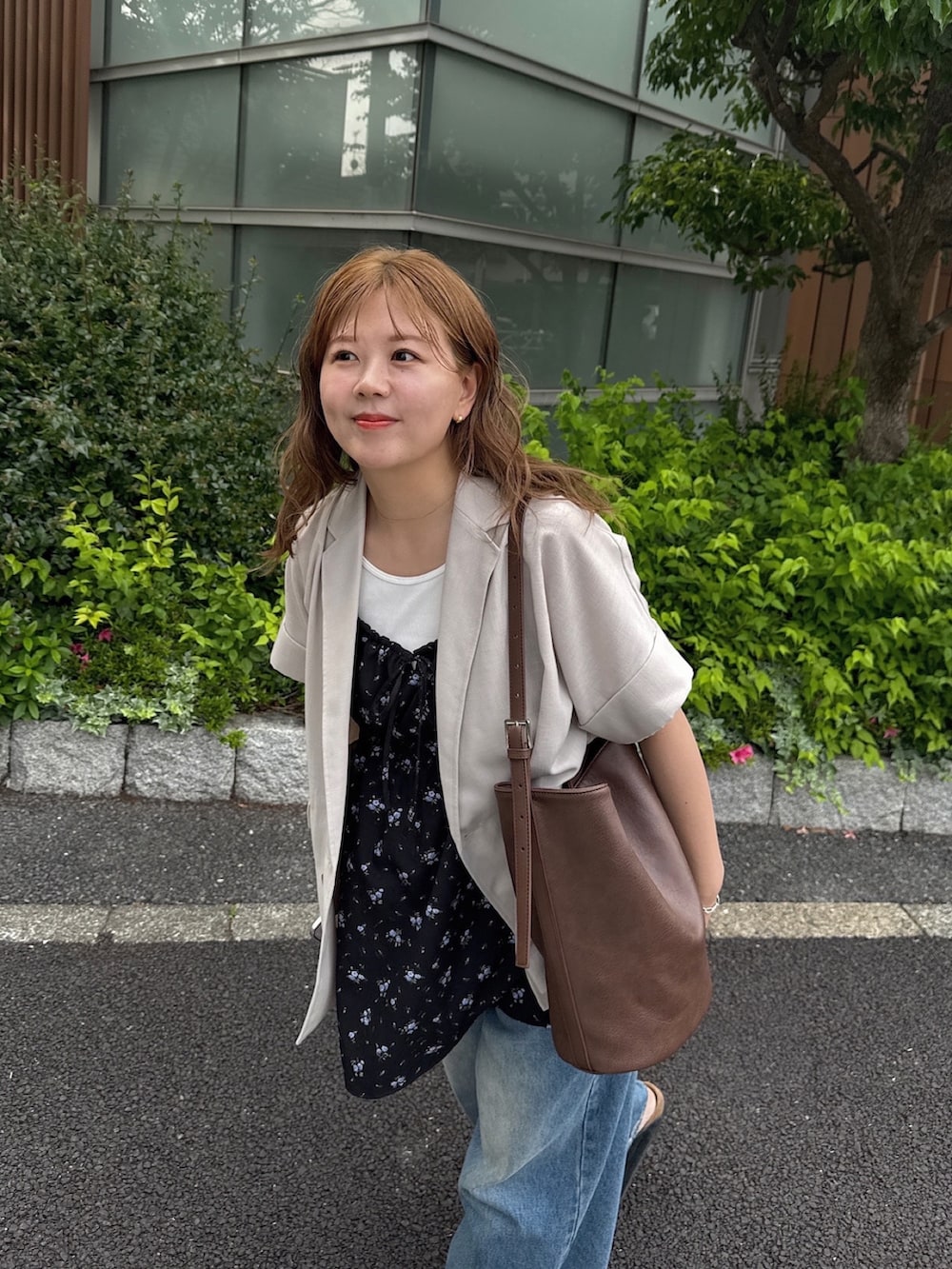 ブルー系のデニムパンツ、ホワイト系のタンクトップ、ブラック系のチュニックを着用したレディースの春コーディネートの2枚目の写真