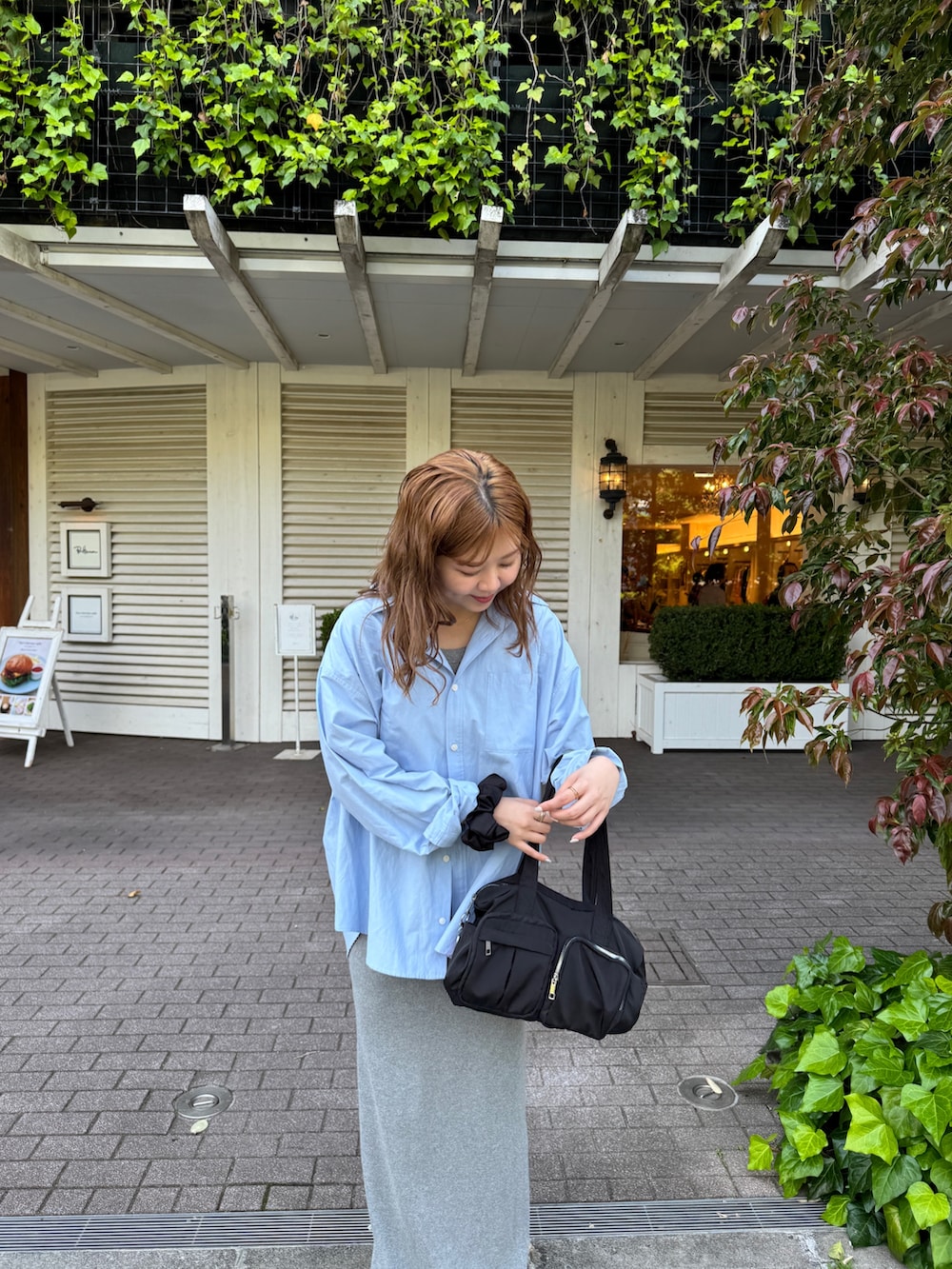 グレー系のワンピース、ブルー系のシャツ/ブラウス、ブラック系のボストンバッグを着用したレディースの春コーディネートの3枚目の写真