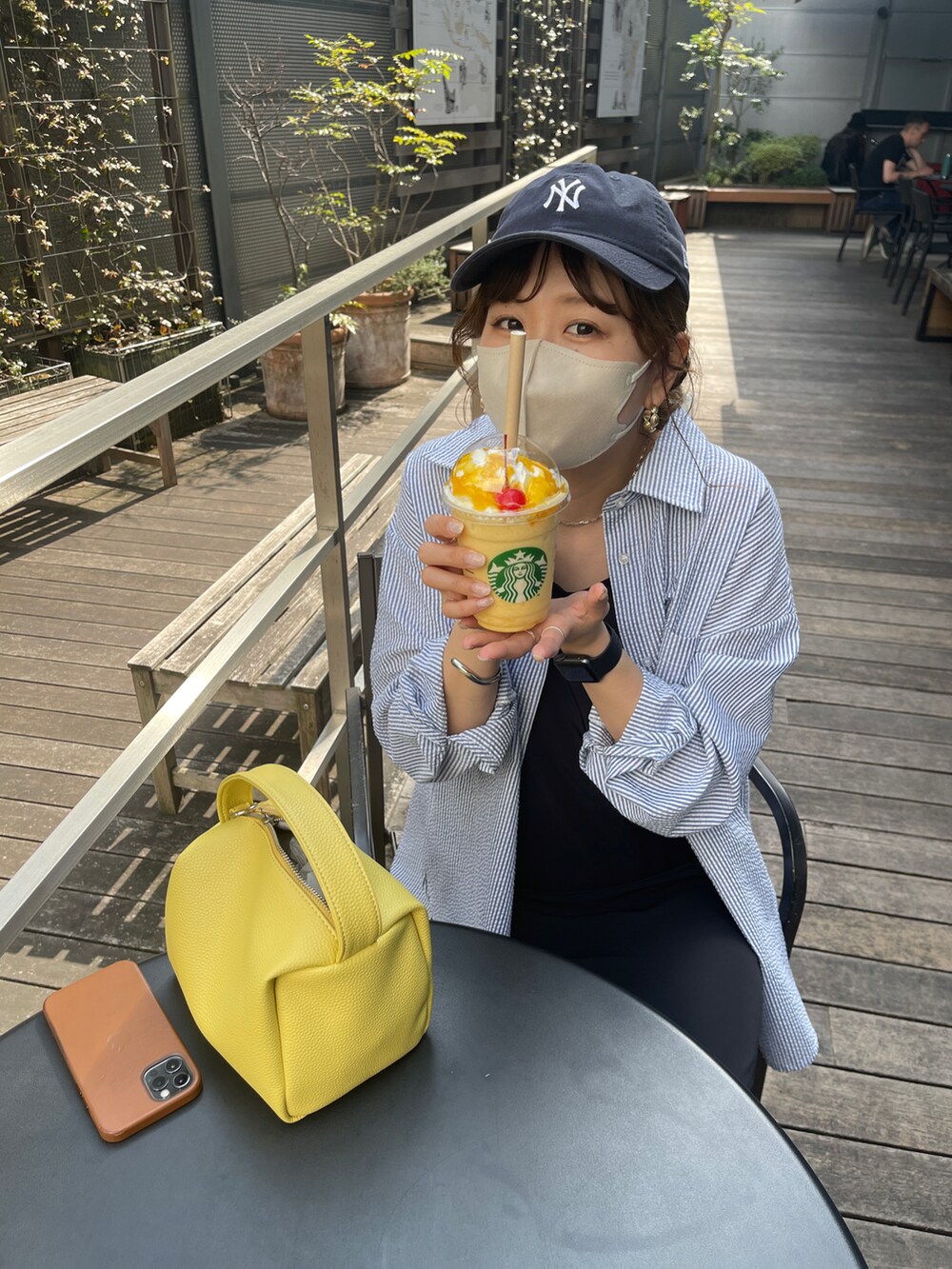 ブラック系のワンピース、ブラック系のサンダル、イエロー系のショルダーバッグを着用したレディースの春コーディネートの4枚目の写真