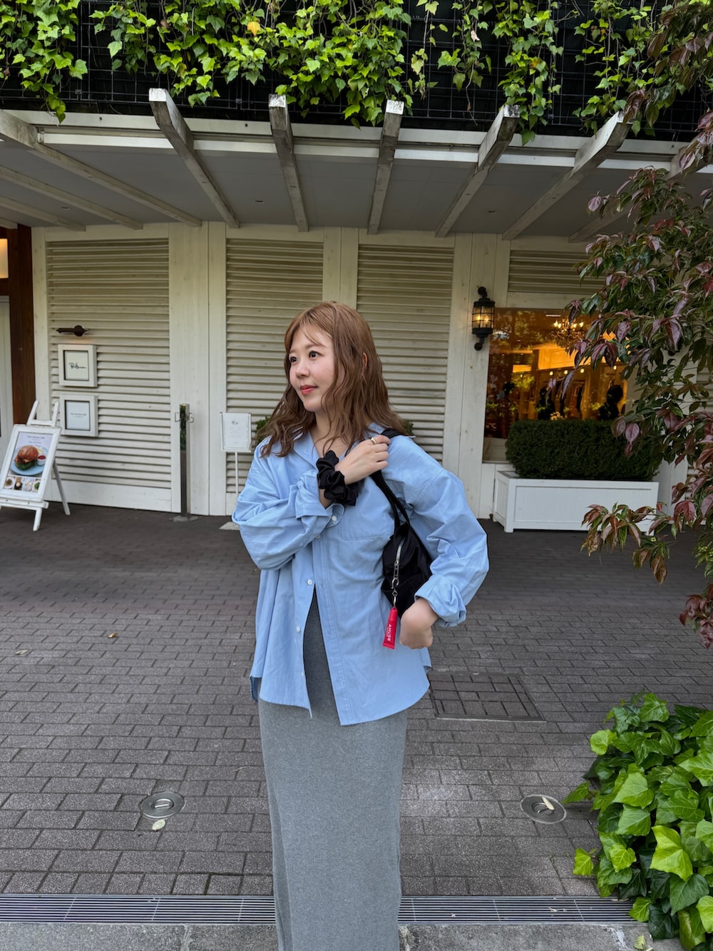 グレー系のワンピース、ブルー系のシャツ/ブラウス、ブラック系のボストンバッグを着用したレディースの春コーディネートの2枚目の写真