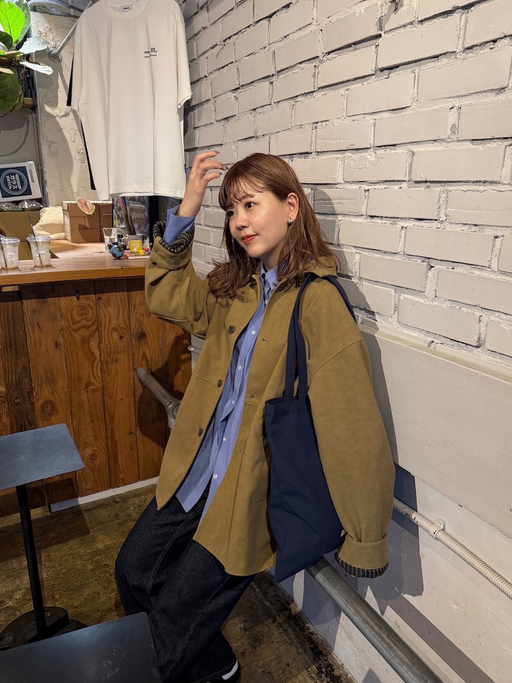 ブルー系のシャツ/ブラウス、ブラウン系のその他アウター、ブルー系のデニムパンツを着用したレディースの秋コーディネートの5枚目の写真