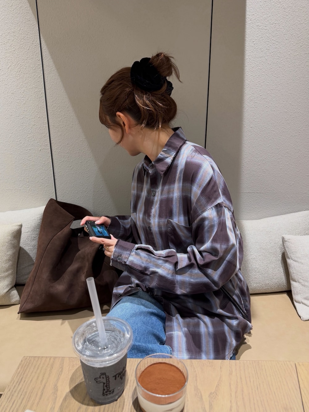 ブラウン系のシャツ/ブラウス、ブルー系のデニムパンツ、ブラック系のボディバッグ/ウエストポーチを着用したレディースの秋コーディネートの4枚目の写真
