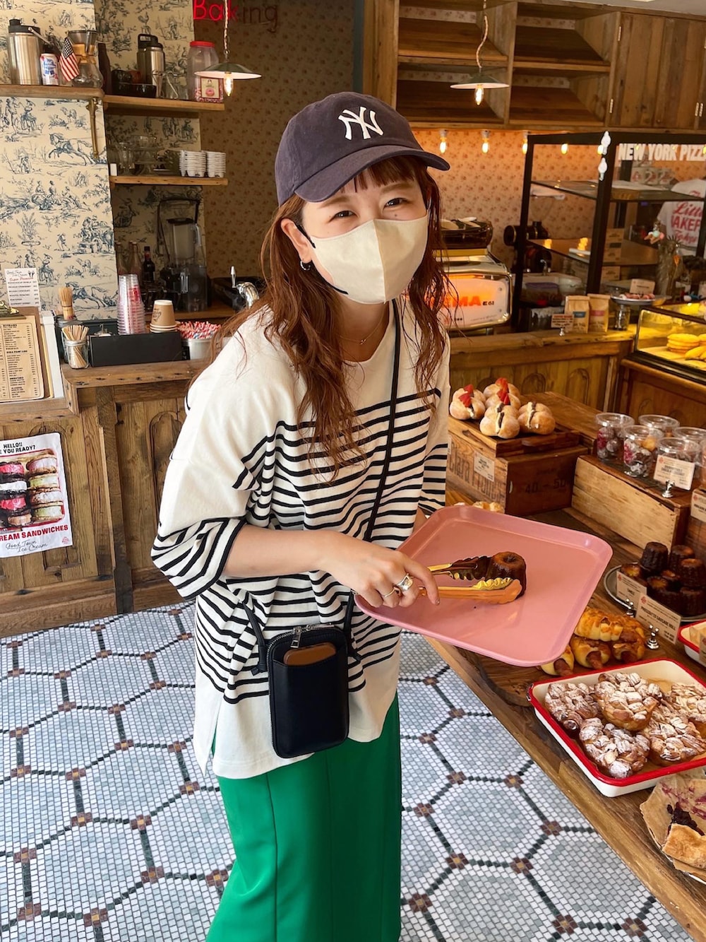 グリーン系のスカート、ブラック系のTシャツ/カットソー、ブラック系のショルダーバッグを着用したレディースの夏コーディネートの2枚目の写真