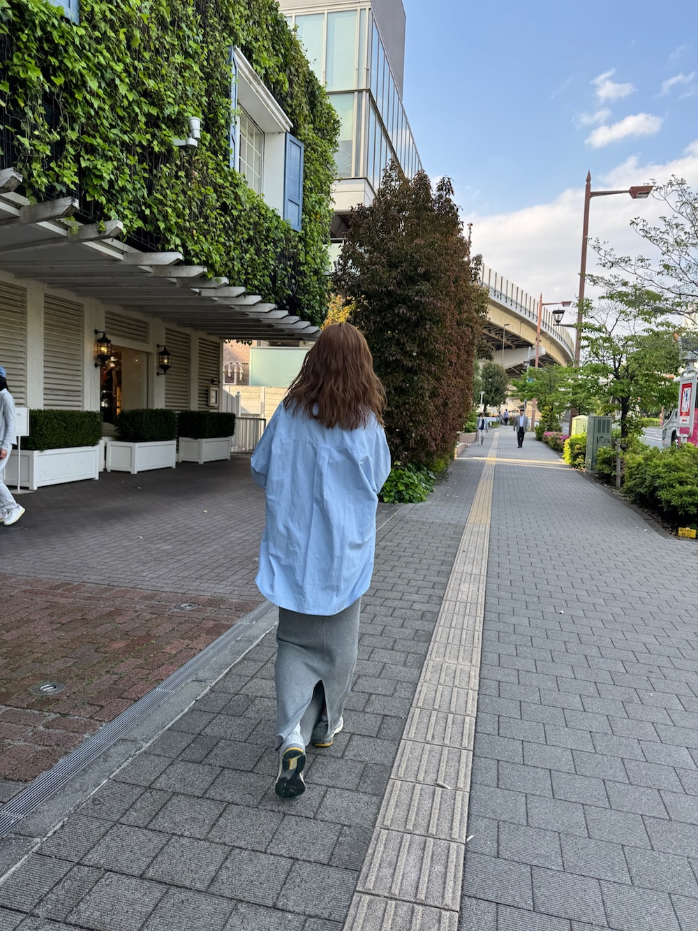 グレー系のワンピース、ブルー系のシャツ/ブラウス、ブラック系のボストンバッグを着用したレディースの春コーディネートの4枚目の写真