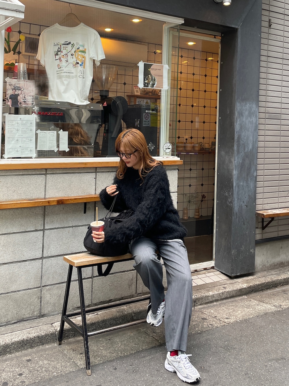 グレー系のスニーカー、ブラック系のバックパック/リュック、ブラック系のニット/セーターを着用したレディースの秋コーディネートの2枚目の写真