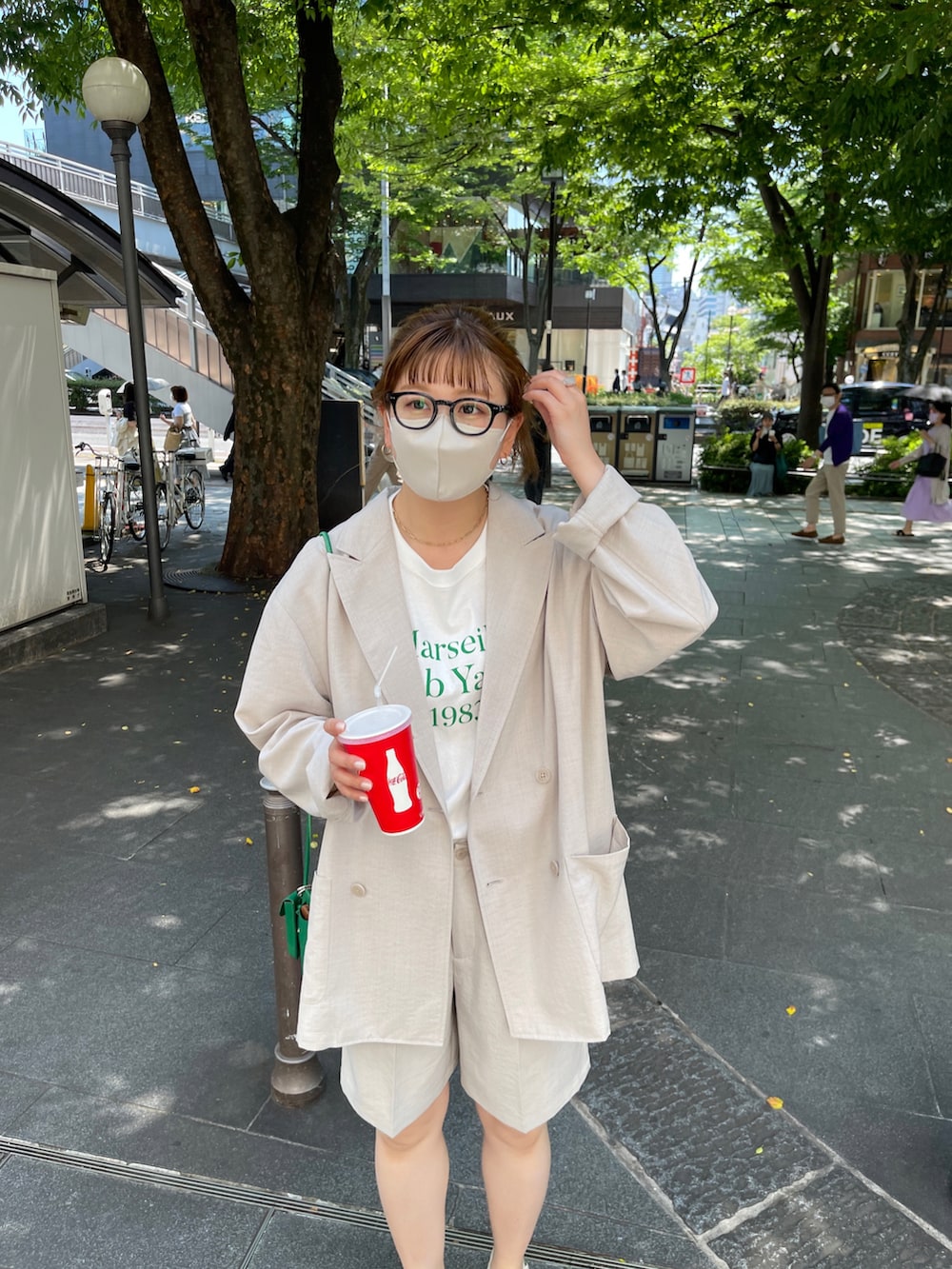 ブラック系のサンダル、オレンジ系のTシャツ/カットソー、ベージュ系のテーラードジャケットを着用したレディースの春コーディネートの2枚目の写真