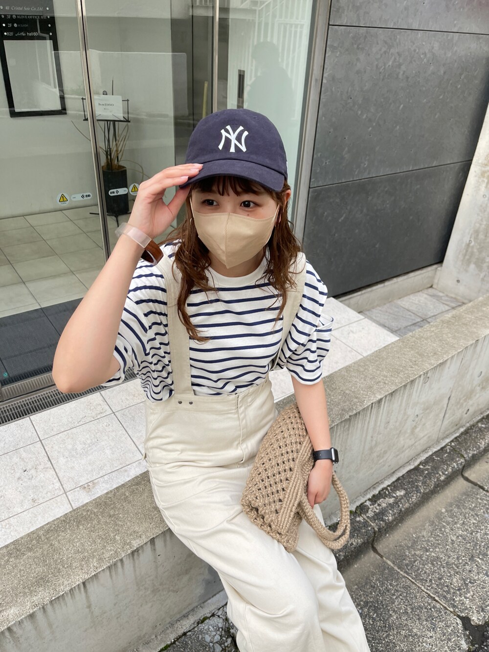 ブラック系のサンダル、ホワイト系のサロペット/オーバーオール、ベージュ系のトートバッグを着用したレディースの春コーディネートの4枚目の写真