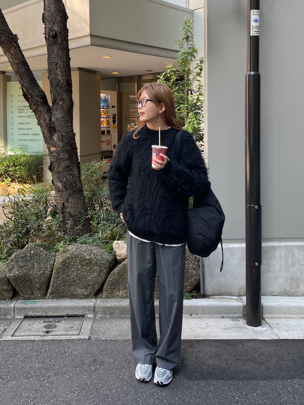 グレー系のスニーカー、ブラック系のバックパック/リュック、ブラック系のニット/セーターを着用したレディースの秋コーディネートの3枚目の写真