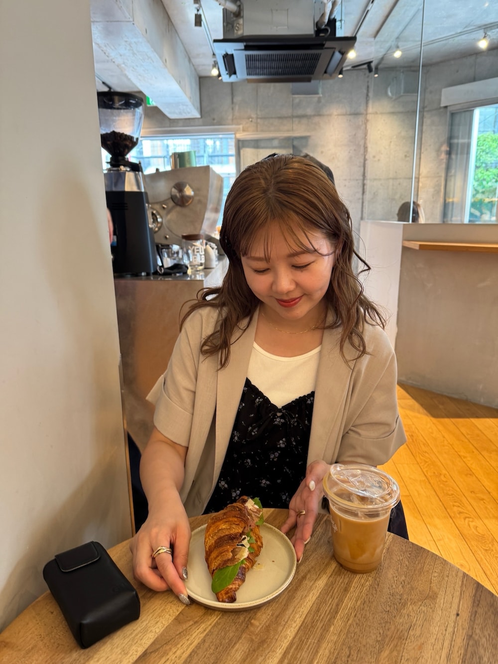 ブルー系のデニムパンツ、ホワイト系のタンクトップ、ブラック系のチュニックを着用したレディースの春コーディネートの3枚目の写真