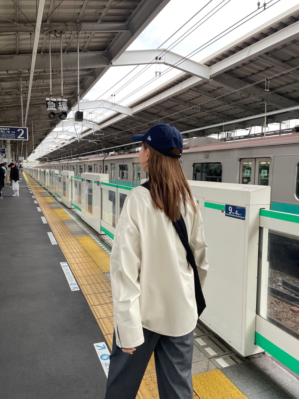 グレー系のスニーカー、ブラック系のショルダーバッグ、ブラック系のニット/セーターを着用したレディースの冬コーディネートの4枚目の写真