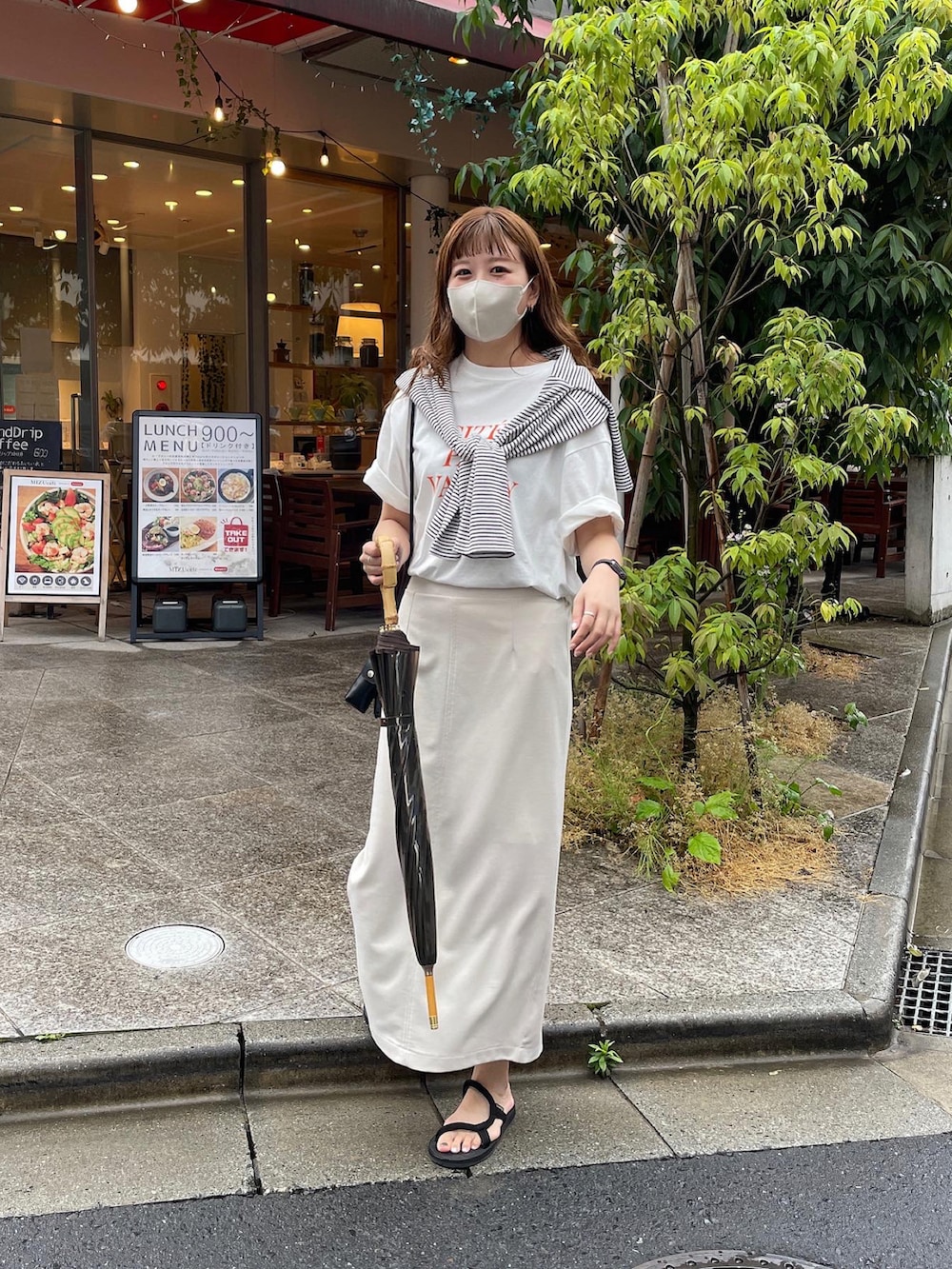 ブラック系のニット/セーター、オレンジ系のTシャツ/カットソー、ブラック系のショルダーバッグを着用したレディースの春コーディネートの2枚目の写真