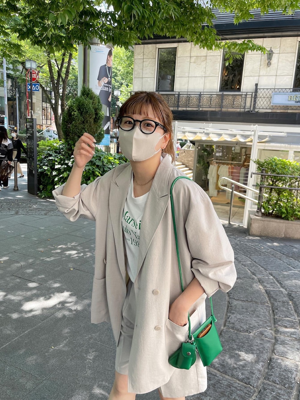 ブラック系のサンダル、オレンジ系のTシャツ/カットソー、ベージュ系のテーラードジャケットを着用したレディースの春コーディネートの3枚目の写真