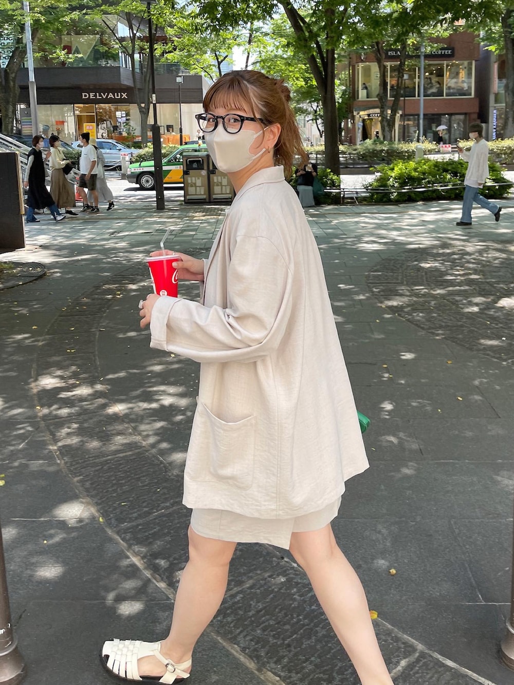 ブラック系のサンダル、オレンジ系のTシャツ/カットソー、ベージュ系のテーラードジャケットを着用したレディースの春コーディネートの4枚目の写真