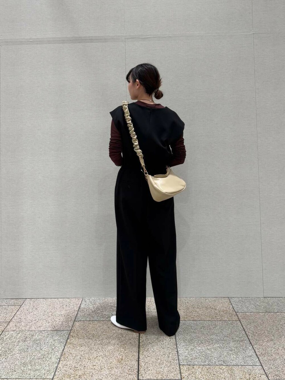 ブラウン系のTシャツ/カットソー、ベージュ系のショルダーバッグ、ブラック系のサロペット/オーバーオールを着用したレディースの冬コーディネートの3枚目の写真