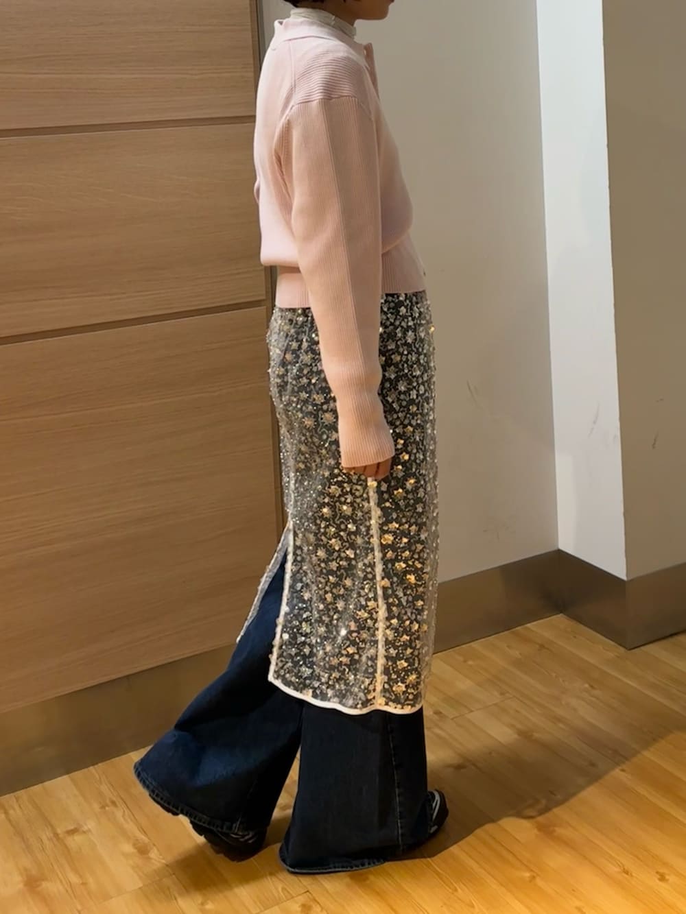 ピンク系のニット/セーター、ホワイト系のスカート、ホワイト系のTシャツ/カットソーを着用したレディースの冬コーディネートの2枚目の写真