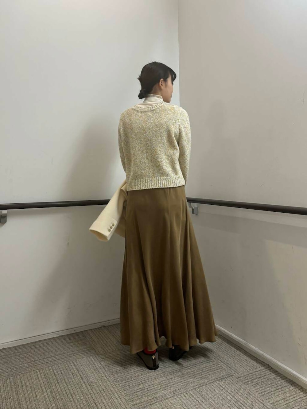 ホワイト系のその他アウター、イエロー系のスカート、ホワイト系のカーディガン/ボレロを着用したレディースの冬コーディネートの8枚目の写真