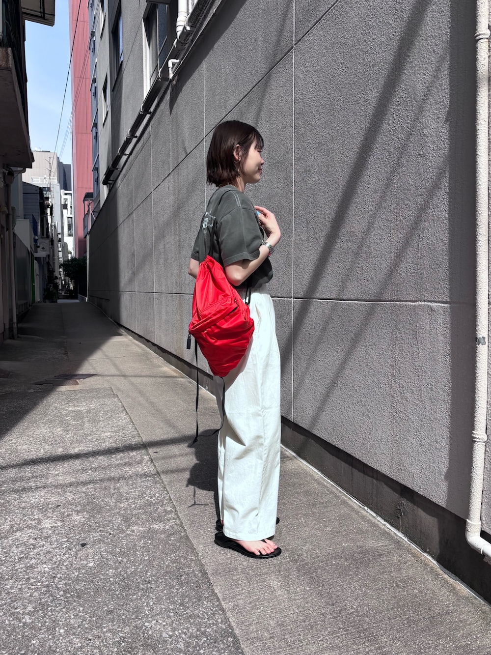 レッド系のバックパック/リュック、ホワイト系のその他パンツ、グレー系のTシャツ/カットソーを着用したレディースの春コーディネートの2枚目の写真