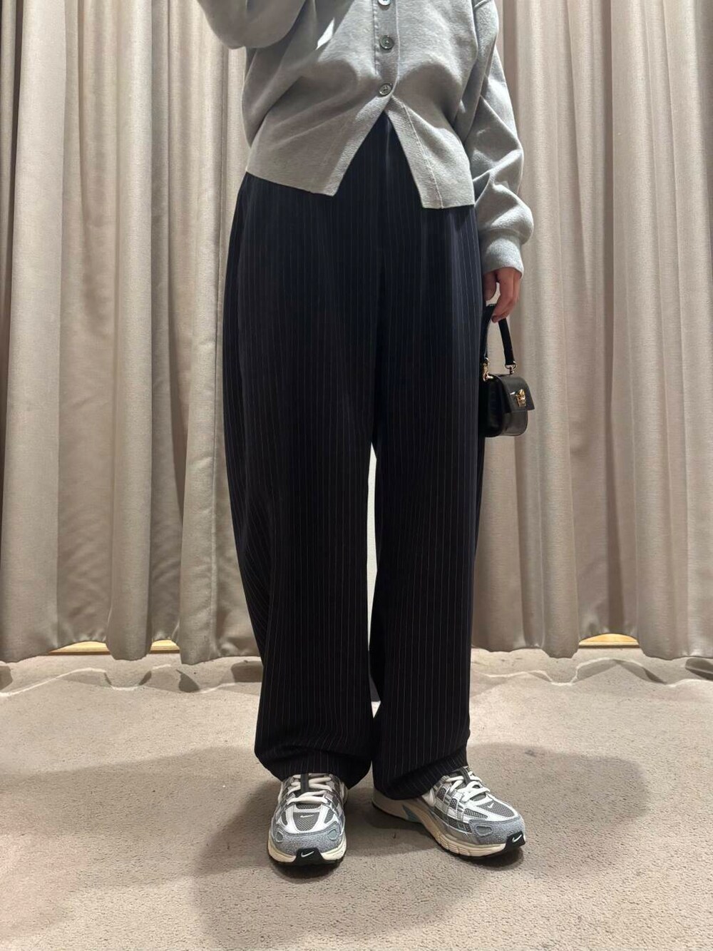 ブラック系のショルダーバッグ、ブルー系のその他パンツ、グレー系のカーディガン/ボレロを着用したレディースの冬コーディネートの3枚目の写真